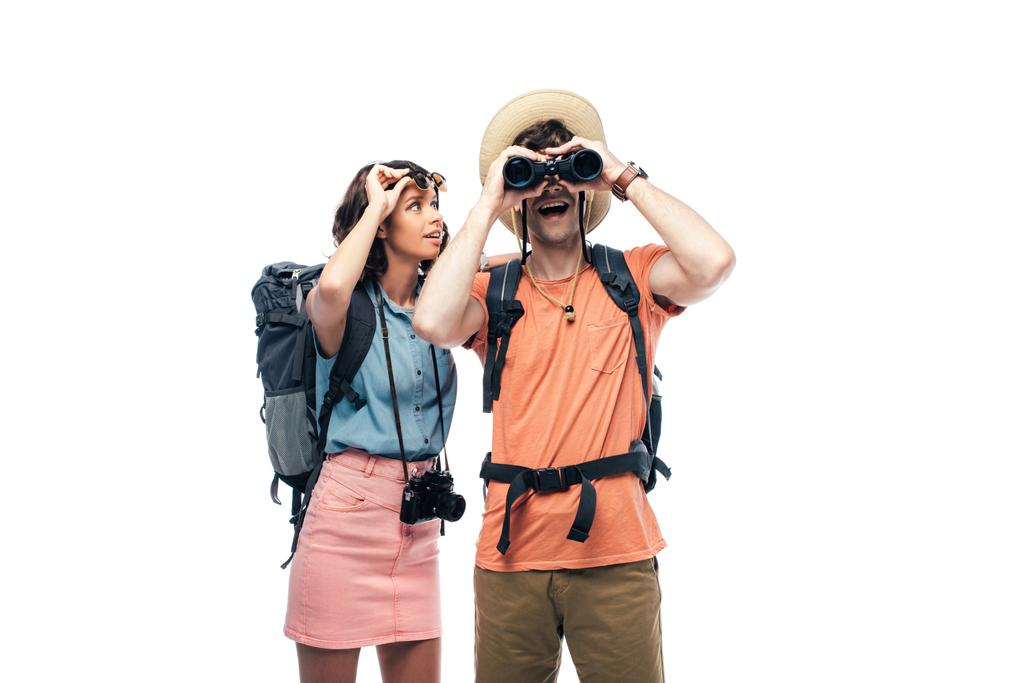 turista excitado mirando en prismáticos cerca de la joven alegre aislado en blanco
 - Foto, imagen