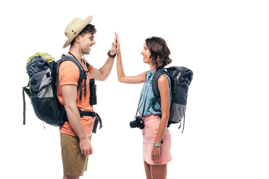 twee vrolijke toeristen met rugzakken geven hoge vijf geïsoleerd op wit - Foto, afbeelding