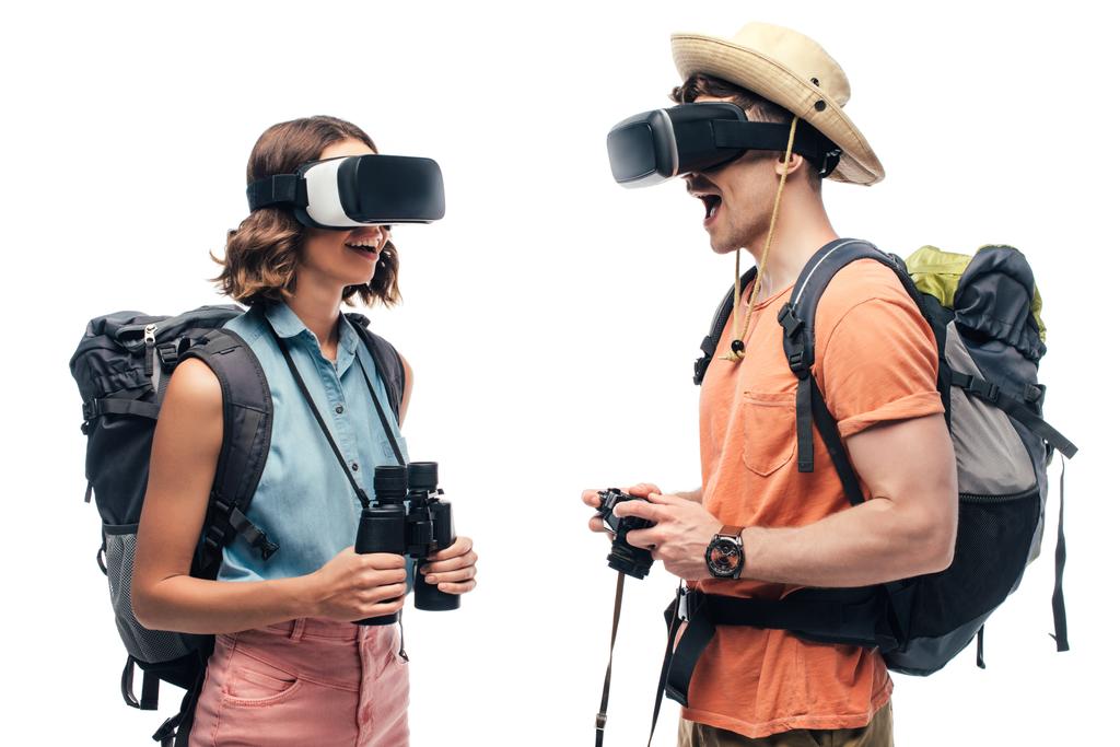 два веселых туриста смотрят друг на друга, используя гарнитуры виртуальной реальности, изолированные на белом
 - Фото, изображение