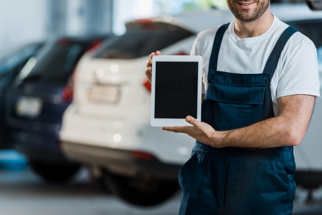 abgeschnittene Ansicht von fröhlichen Automechaniker hält digitales Tablet mit leerem Bildschirm  - Foto, Bild