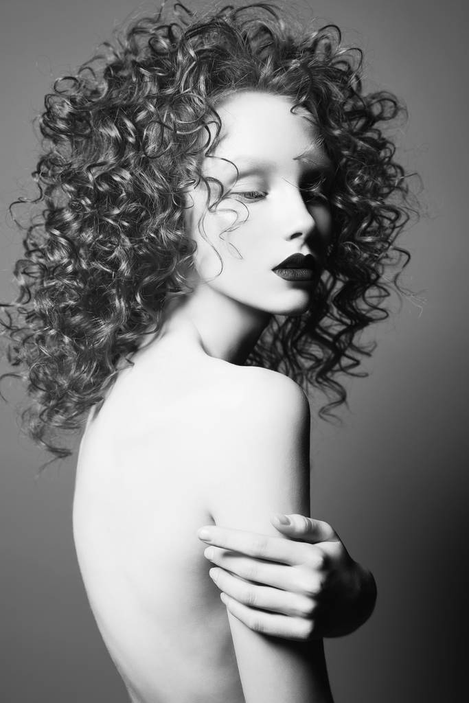 Όμορφη γυμνή γυναίκα με σγουρά μαλλιά και μαύρα χείλη. - Φωτογραφία, εικόνα