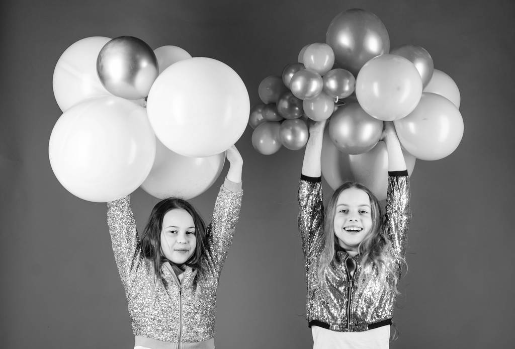 Gelukkige momenten creëren. Kleine meisjes die plezier hebben met kleurrijke ballonnen. Gelukkige kinderen spelen met luchtballonnen. Ballonnen gebruiken voor verjaardagsviering. De ballonnen zijn feestelijk. - Foto, afbeelding