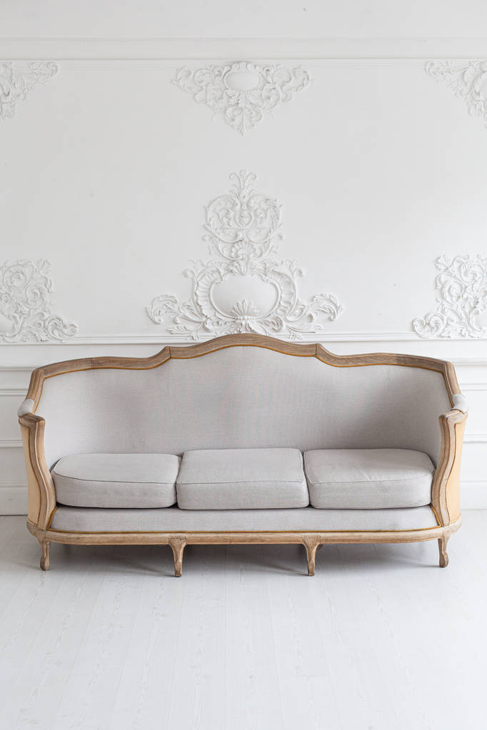 luxuriöses, helles Rokoko-Interieur mit großem Sofa und Stuck an den Wänden. Selektiver Fokus. - Foto, Bild