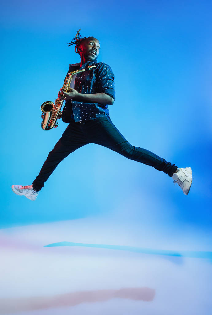 Jonge Afro-Amerikaanse jazzmuzikant spelen de saxofoon - Foto, afbeelding