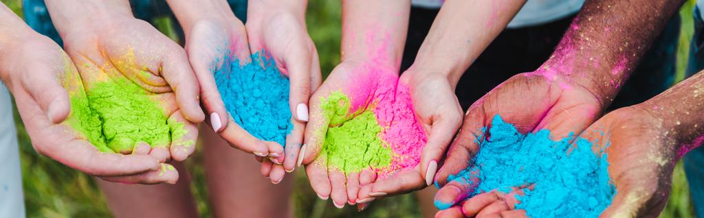 tiro panorâmico de amigos multiculturais segurando tintas holi coloridas em mãos
  - Foto, Imagem