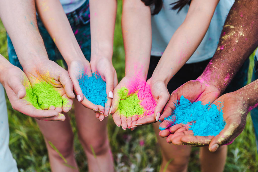 przycięte widok wielokulturowych przyjaciół posiadających kolorowe farby Holi w rękach  - Zdjęcie, obraz