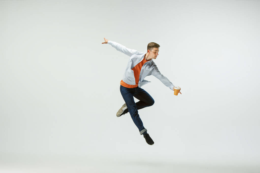 Mies työskentelee toimistossa ja hyppää eristyksissä studion taustalla
 - Valokuva, kuva