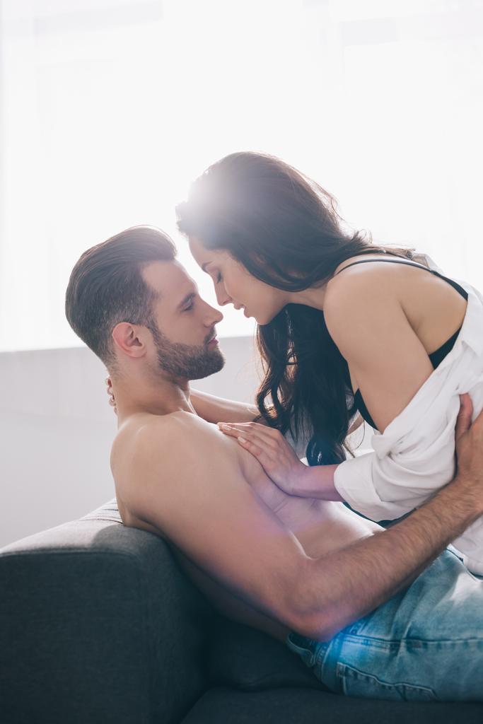 side view of shirtless and handsome man kissing and hugging with brunette woman  - Photo, Image