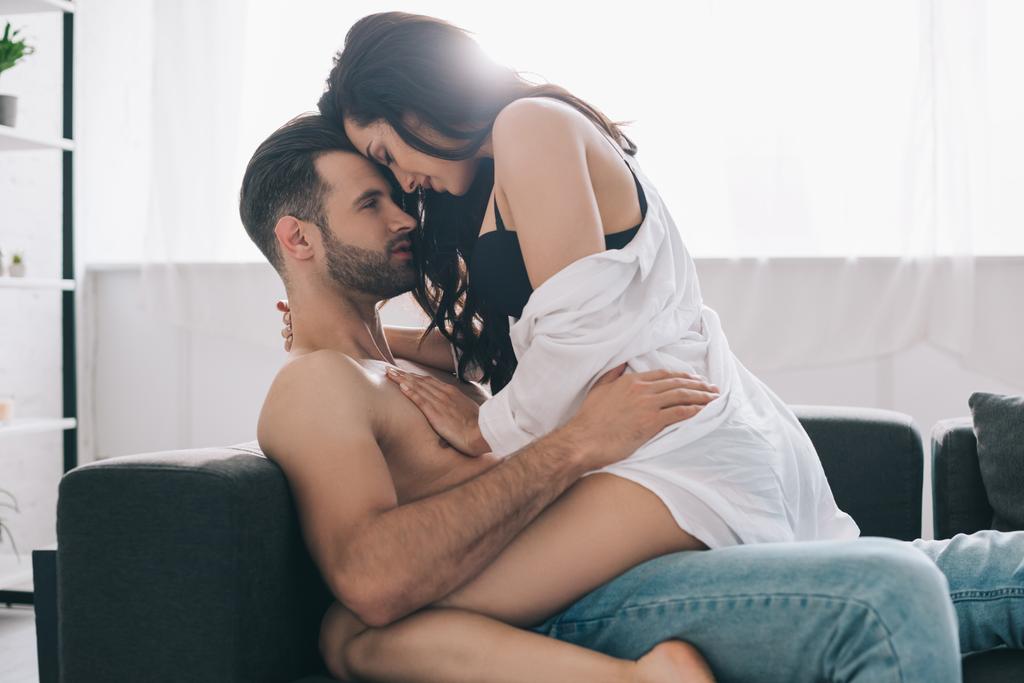hemdloser und gutaussehender Mann küsst und umarmt brünette Frau  - Foto, Bild