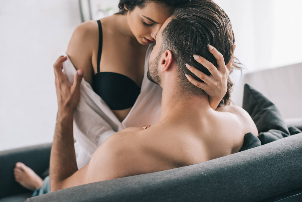 Мужчина без рубашки обнимается и целуется с брюнеткой и сексуальной женщиной в лифчике
  - Фото, изображение