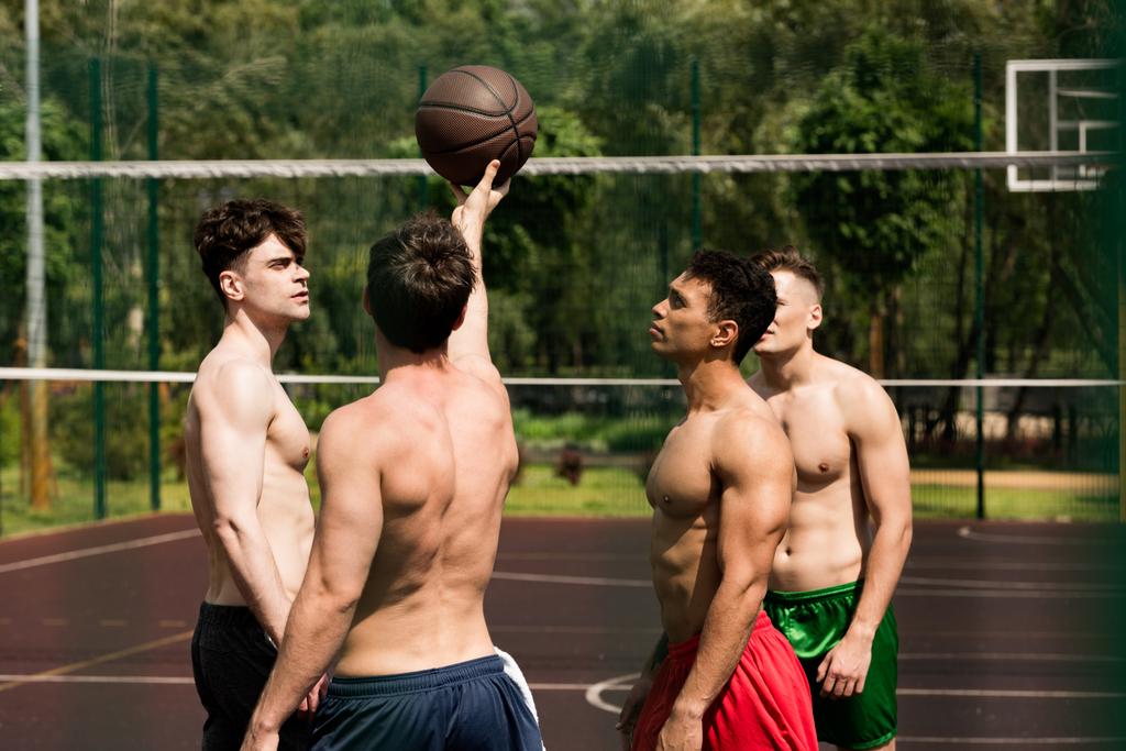 バスケットボールコートで4人のセクシーなシャツレスバスケットボール選手のトレーニング - 写真・画像