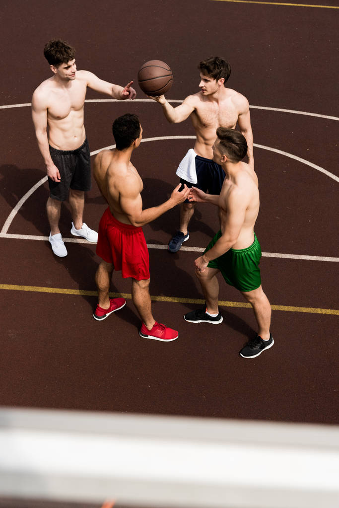 εναέρια θέα από τέσσερις παίκτες μπάσκετ χωρίς πουκάμισο με μπάλα στο γήπεδο μπάσκετ - Φωτογραφία, εικόνα