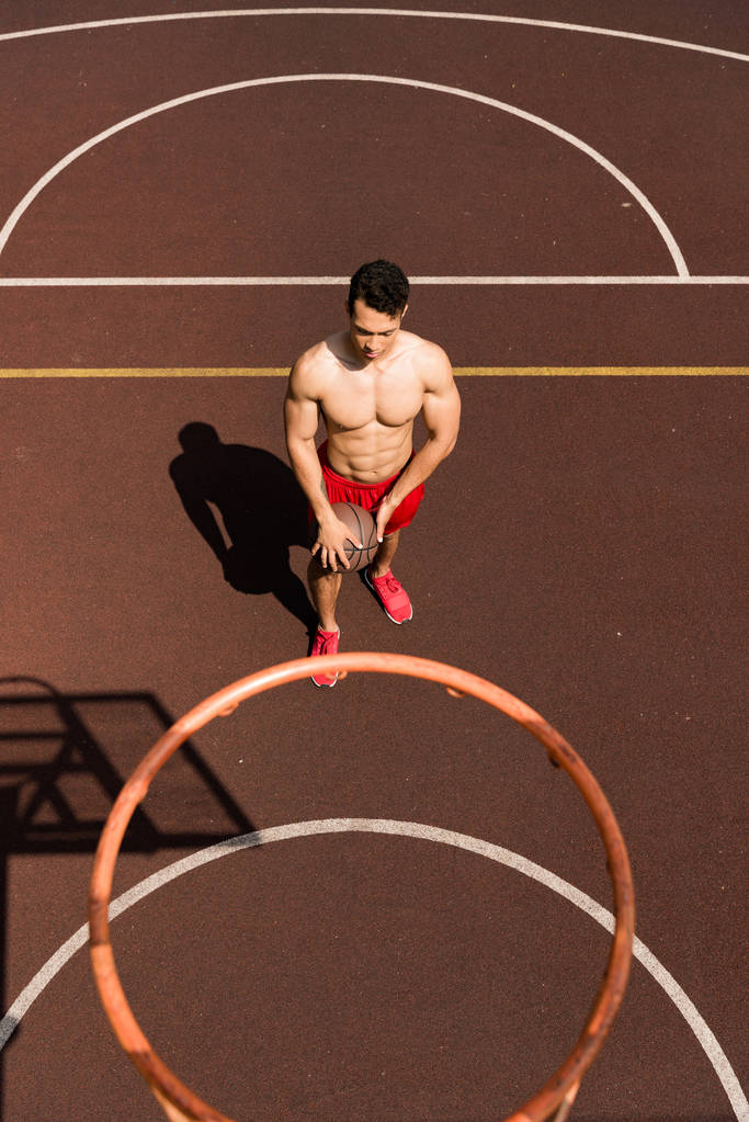 vue aérienne du joueur de basket-ball mixte sans chemise sexy avec balle au terrain de basket-ball
 - Photo, image