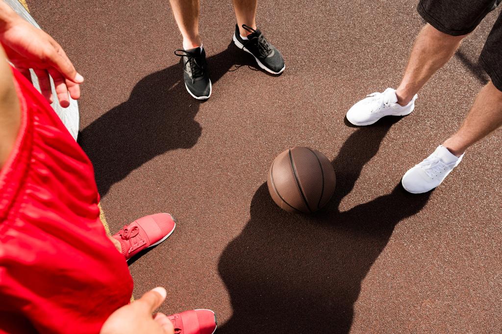 περικομμένη θέα τριών αθλητών με μπάλα στο γήπεδο μπάσκετ - Φωτογραφία, εικόνα