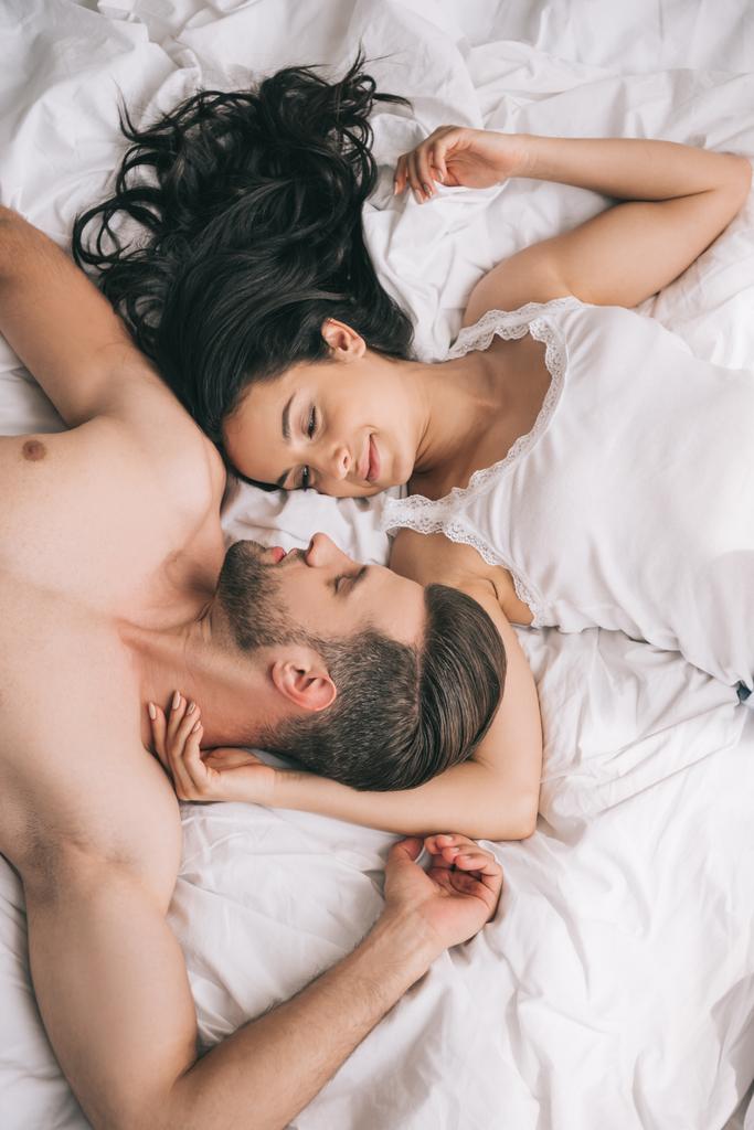 top view of handsome and shirtless man lying with attractive woman on bed  - Photo, Image