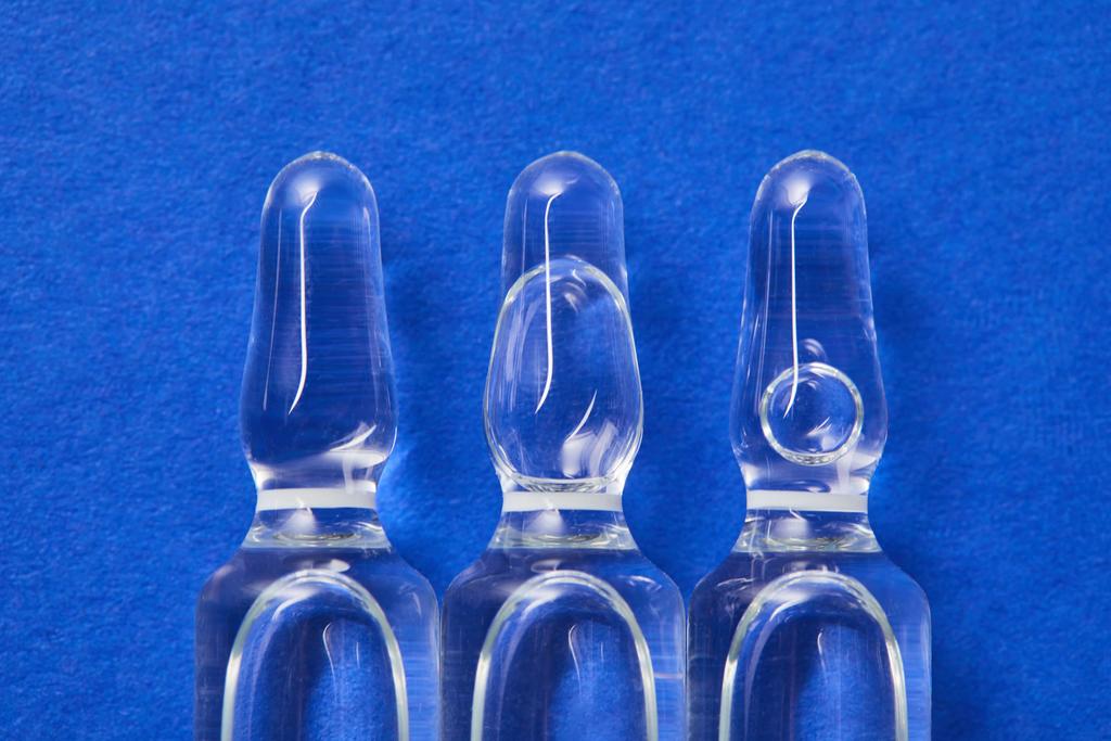 vista de cerca de pocas ampollas con líquido de tambor en la superficie azul
 - Foto, Imagen