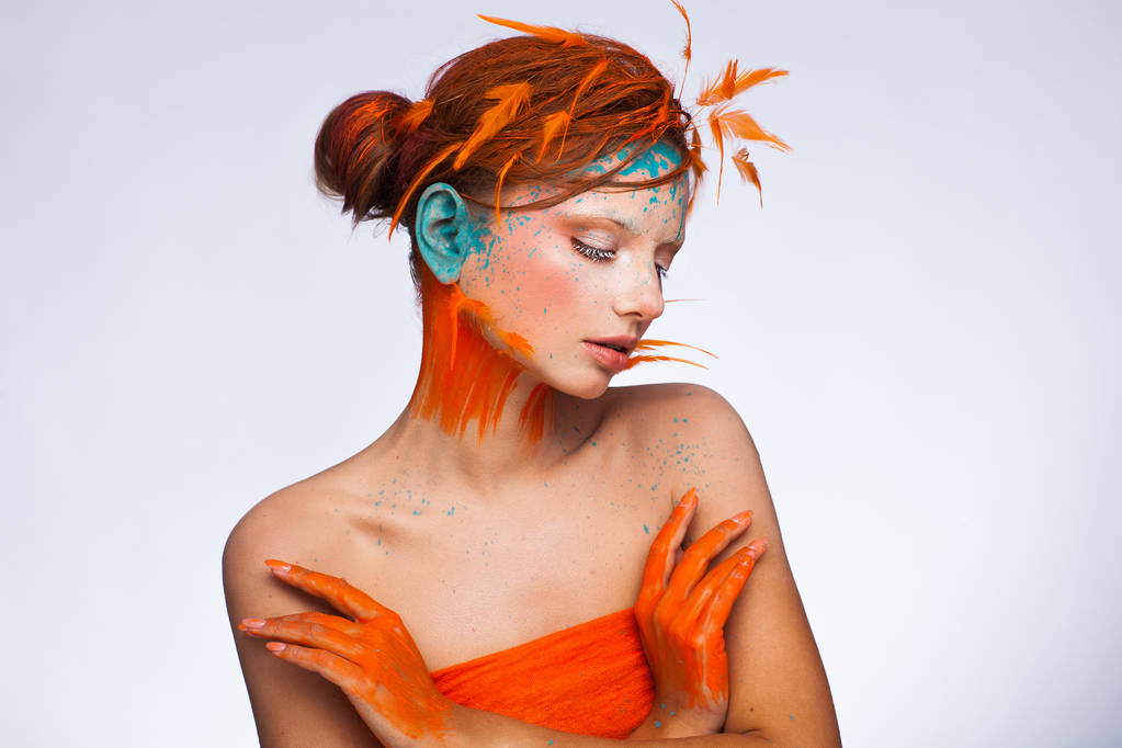 Retrato de um belo modelo com maquiagem criativa e penteado usando penas de laranja
 - Foto, Imagem