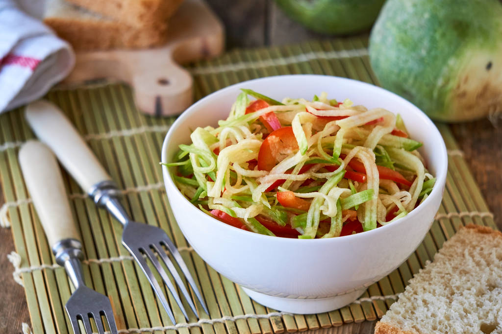 Salade met groene radijs en paprika in een witte kom                                - Foto, afbeelding