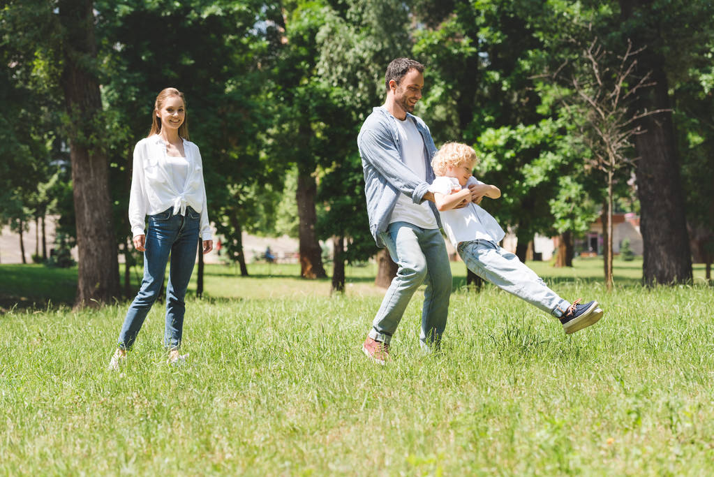 razem rodzina spędzać czas, ojciec Spinning syna w parku - Zdjęcie, obraz