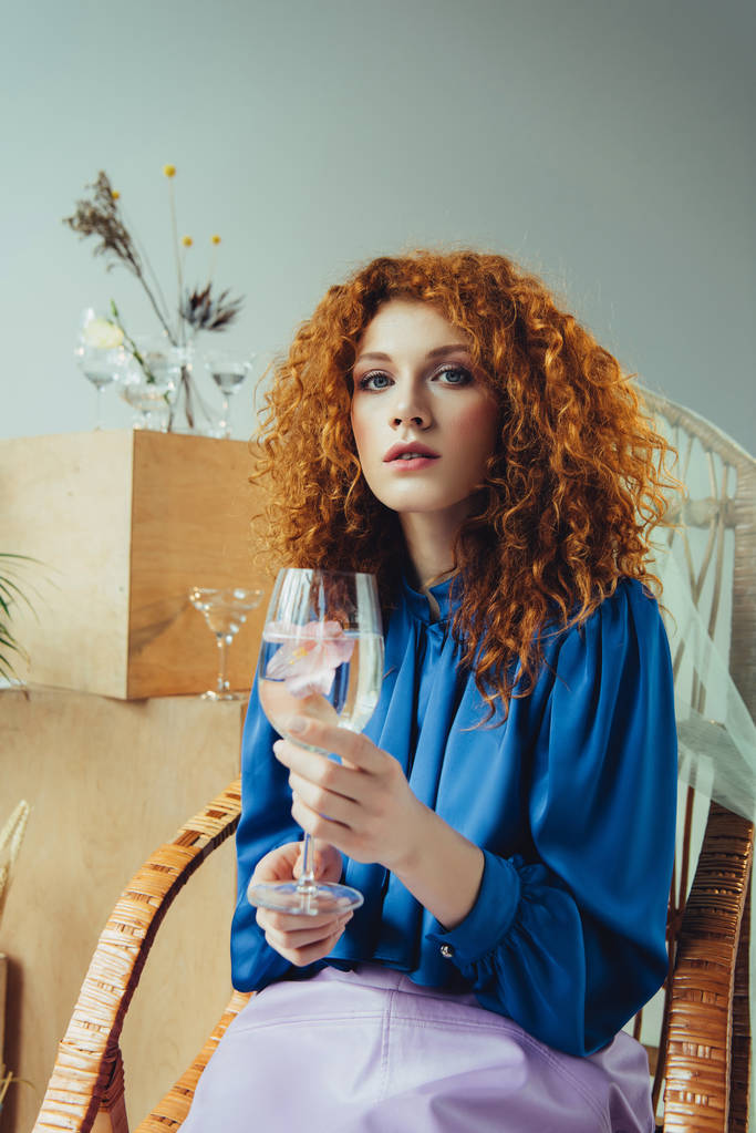 beautiful stylish redhead woman holding glass with flower - Photo, Image