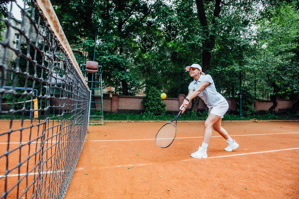 tennisspeelster op de tennisbaan, focus op de voorgrond - Foto, afbeelding