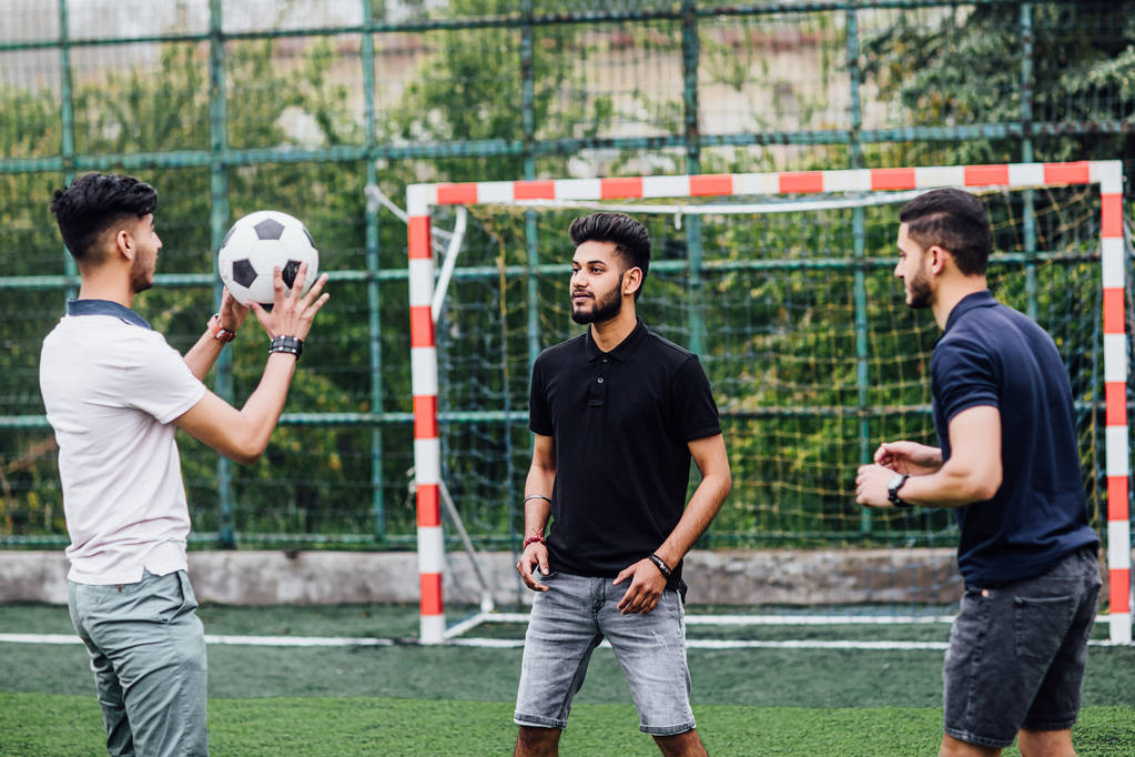 hombres guapos jugando al fútbol en el campo juntos
 - Foto, Imagen