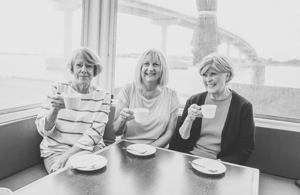 Vrolijke bejaarde vrienden die samen thee of koffie hebben. Senior vriendinnen chatten lachen en het hebben van plezier in coffeeshop in stay actief in pensioen levensstijl en vriendschap of gezelschap concept. - Foto, afbeelding