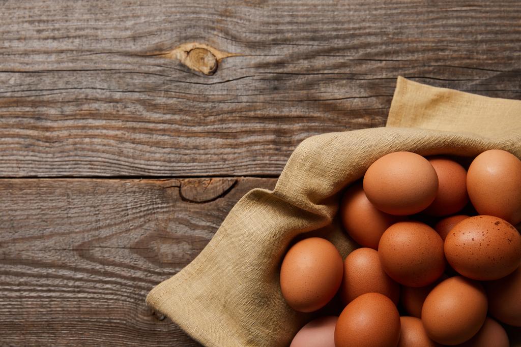  vista superior de ovos de galinha no pano na mesa de madeira
 - Foto, Imagem