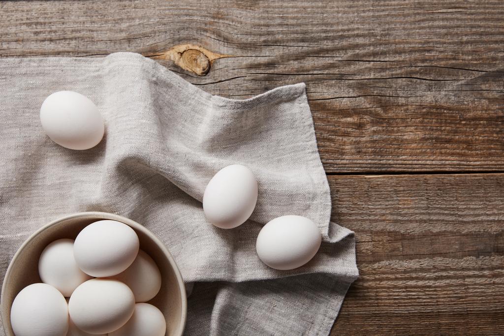 felülnézet csirke tojások tálban fából készült asztal ruhával - Fotó, kép
