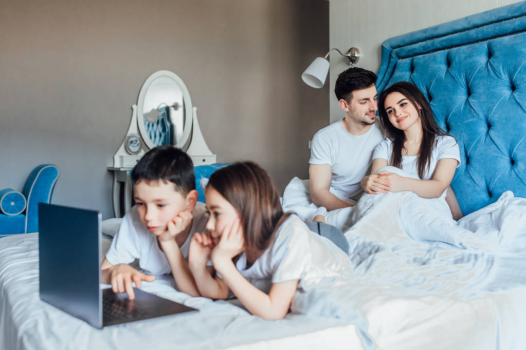сім'я проводить час разом у ліжку вдома
   - Фото, зображення