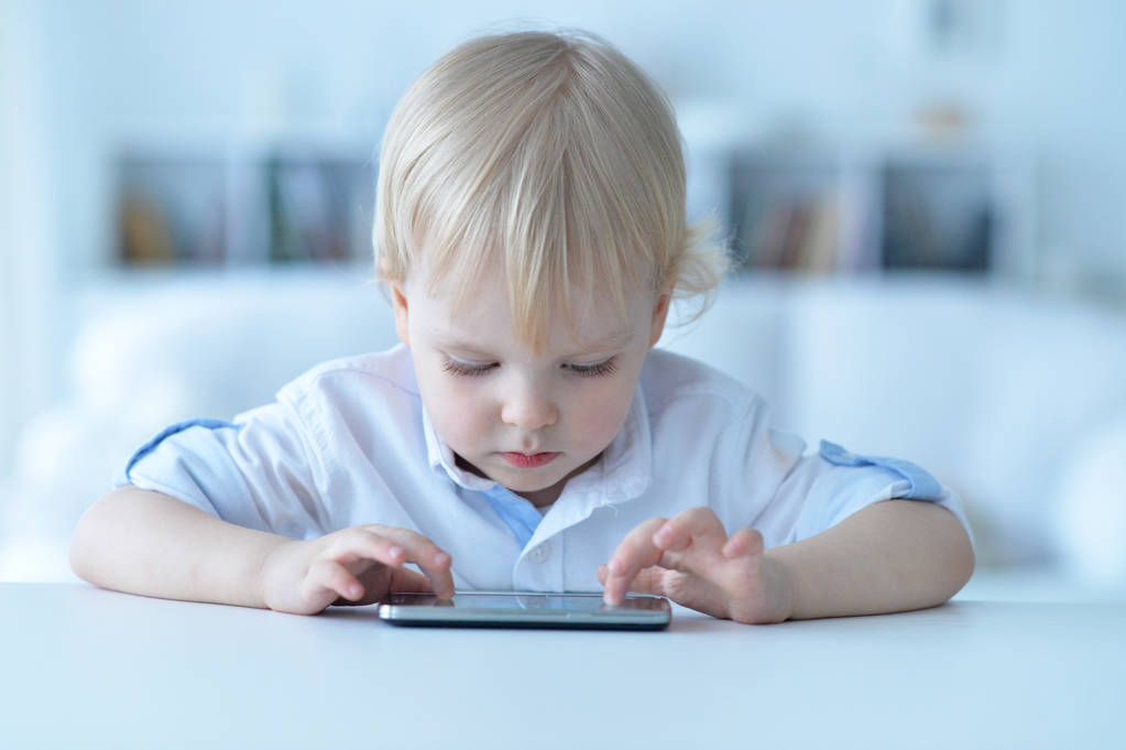 мальчик со смартфоном играет в игру дома
  - Фото, изображение