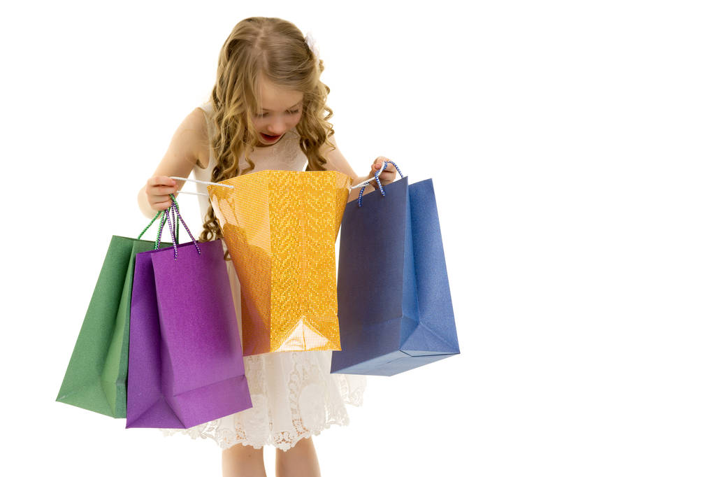 Little girl with multi-colored bags in their hands. - Photo, Image