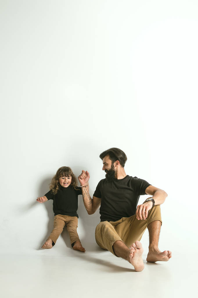 Père jouant avec le jeune fils sur fond de studio blanc
 - Photo, image
