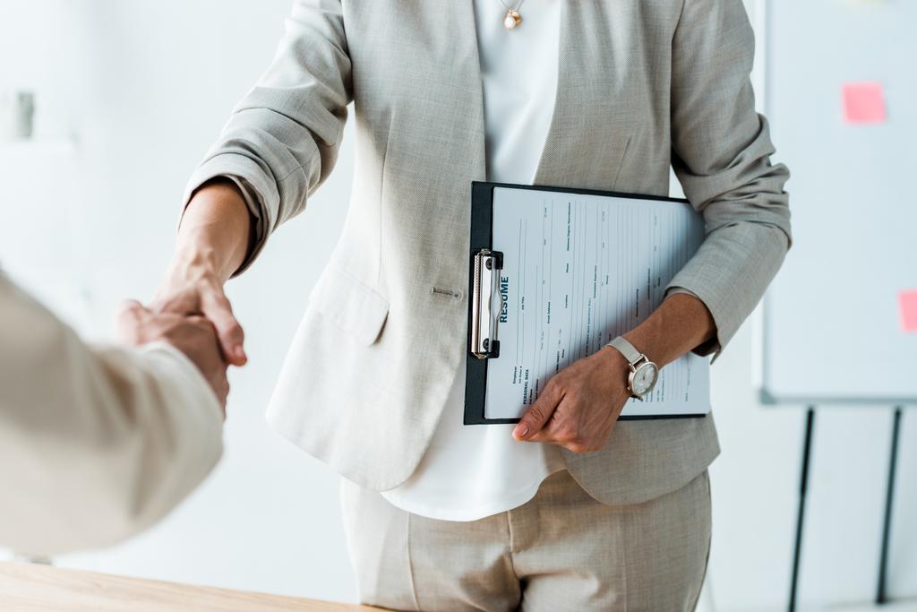 cropped view of recruiter and employee shaking hands in office  - Photo, Image