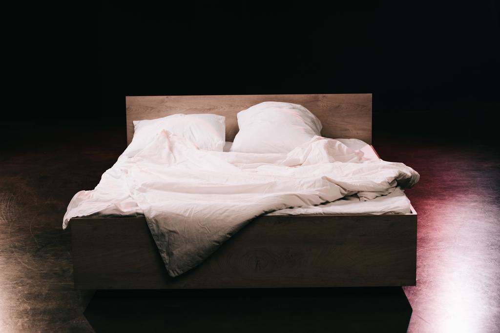 siyah yatak odasında beyaz temiz yatak çarşafları üzerinde yumuşak yastıklar  - Fotoğraf, Görsel