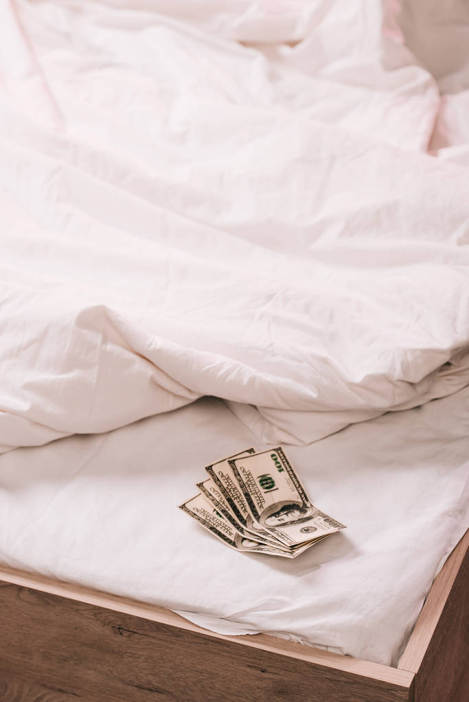 foco seletivo das notas de dólar na roupa de cama branca
  - Foto, Imagem