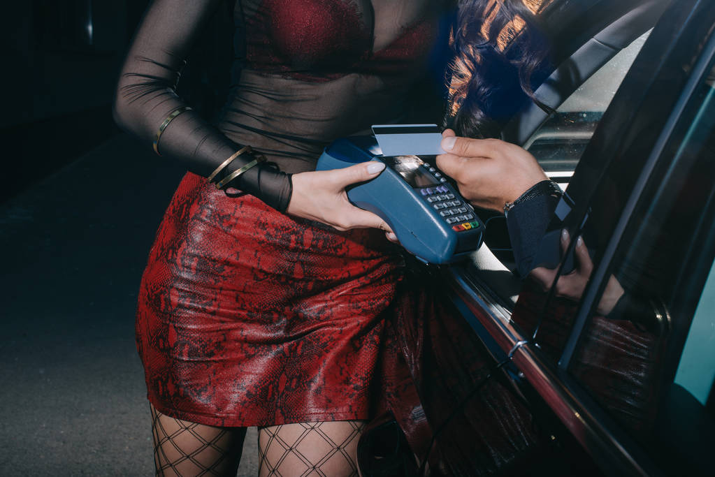 corte vista de homem pagando por cartão de crédito enquanto prostituta segurando leitor de cartão de crédito
  - Foto, Imagem