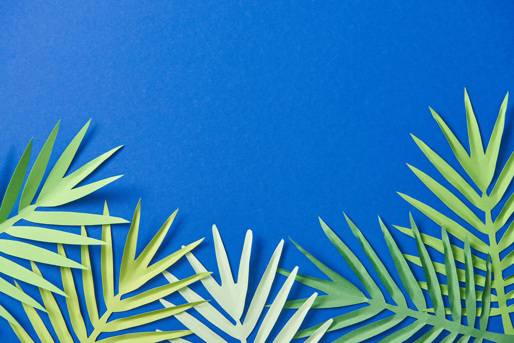 верхний вид бумаги вырезать экзотические листья на синем фоне с копировальным пространством
 - Фото, изображение
