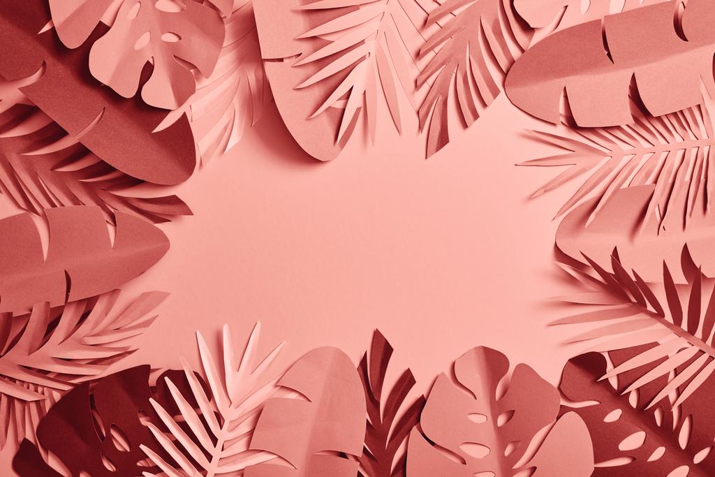 Top uitzicht van tropische papier gesneden Palm bladeren op roze achtergrond - Foto, afbeelding