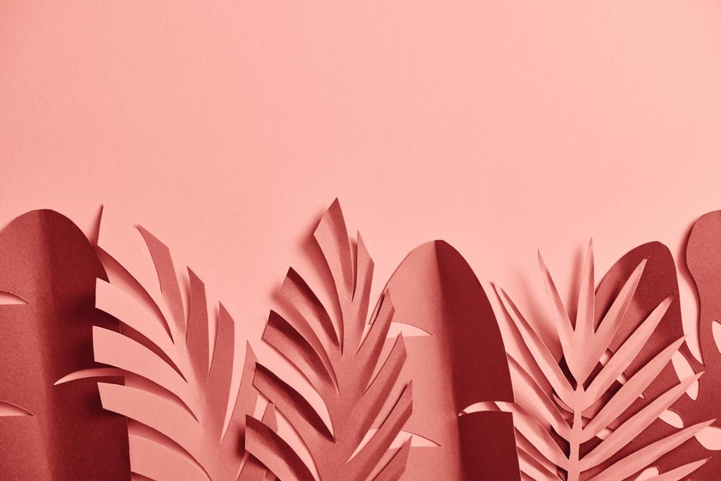 top view of decorative paper cut palm leaves on pink background with copy space - Photo, Image