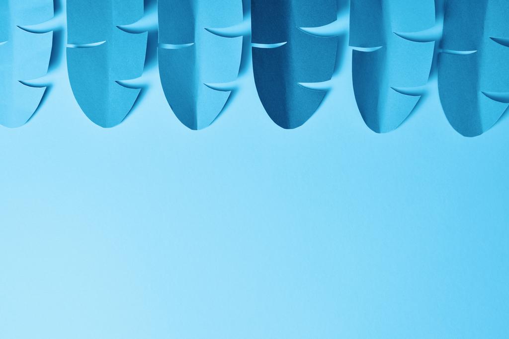 επίπεδη θέση με μπλε μινιμαλιστικό χαρτί κομμένα φύλλα παλάμης σε μπλε φόντο με χώρο αντιγραφής - Φωτογραφία, εικόνα