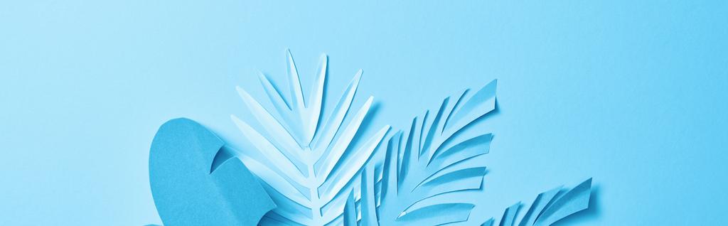 Widok z góry niebieski egzotyczny papier cięte liści palmowych na niebieskim tle z miejsca kopiowania, panoramiczny strzał - Zdjęcie, obraz