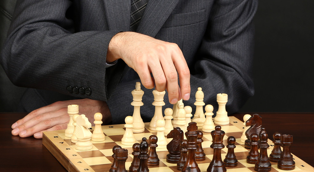 Joven hombre de negocios jugando ajedrez sobre fondo negro
 - Foto, imagen
