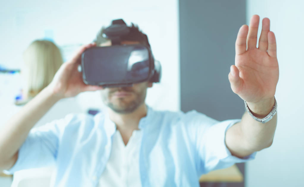 Młody programista męski testujący nową aplikację z okularami 3D wirtualnej rzeczywistości w biurze. - Zdjęcie, obraz