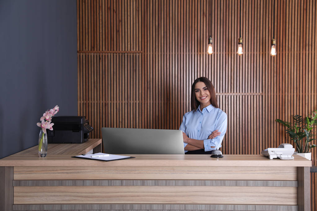 Portrait of receptionist at desk in lobby - Photo, Image