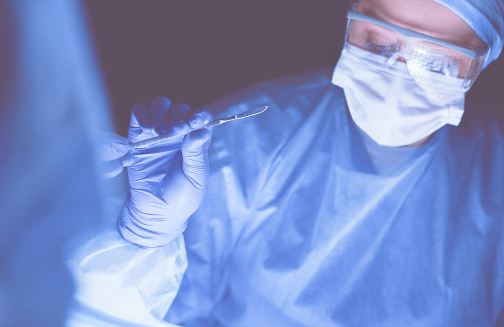 Immagine ritagliata di bisturi presi medici che eseguono un intervento chirurgico. - Foto, immagini