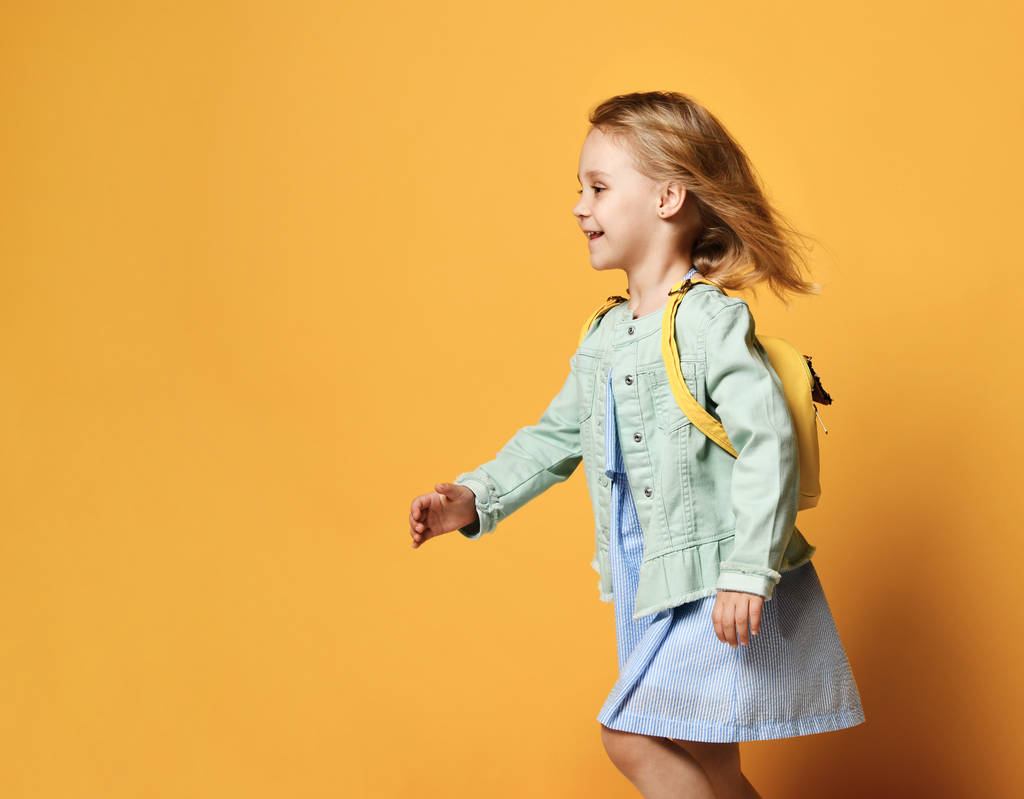 Ολόσωμο πορτρέτο του ένα χαριτωμένο μικρό παιδί κορίτσι σε ένα κομψό φόρεμα και ντένιμ. - Φωτογραφία, εικόνα