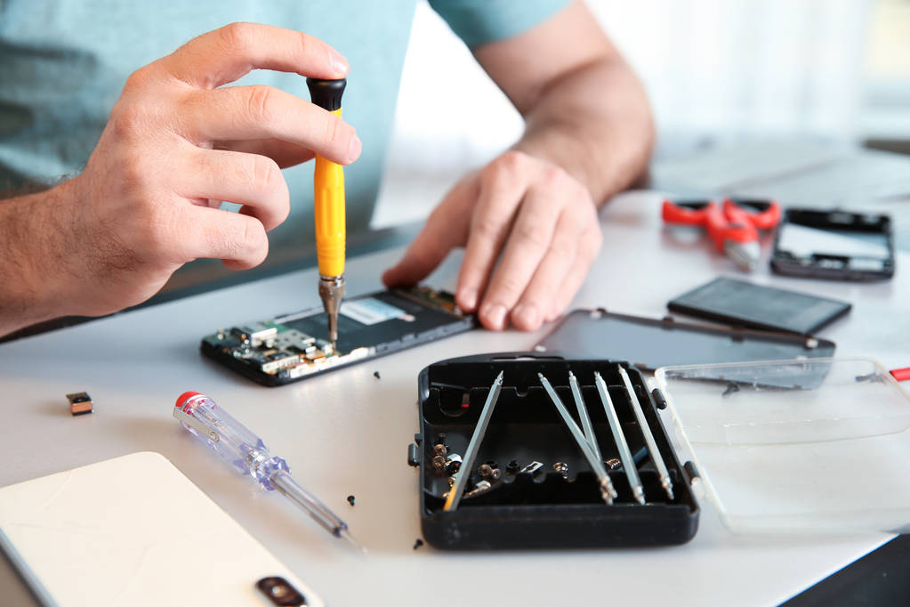 Technicien réparer téléphone portable à table, gros plan
 - Photo, image