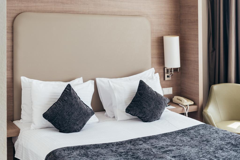 párnák és párnák a kényelmes szállodai szobában - Fotó, kép