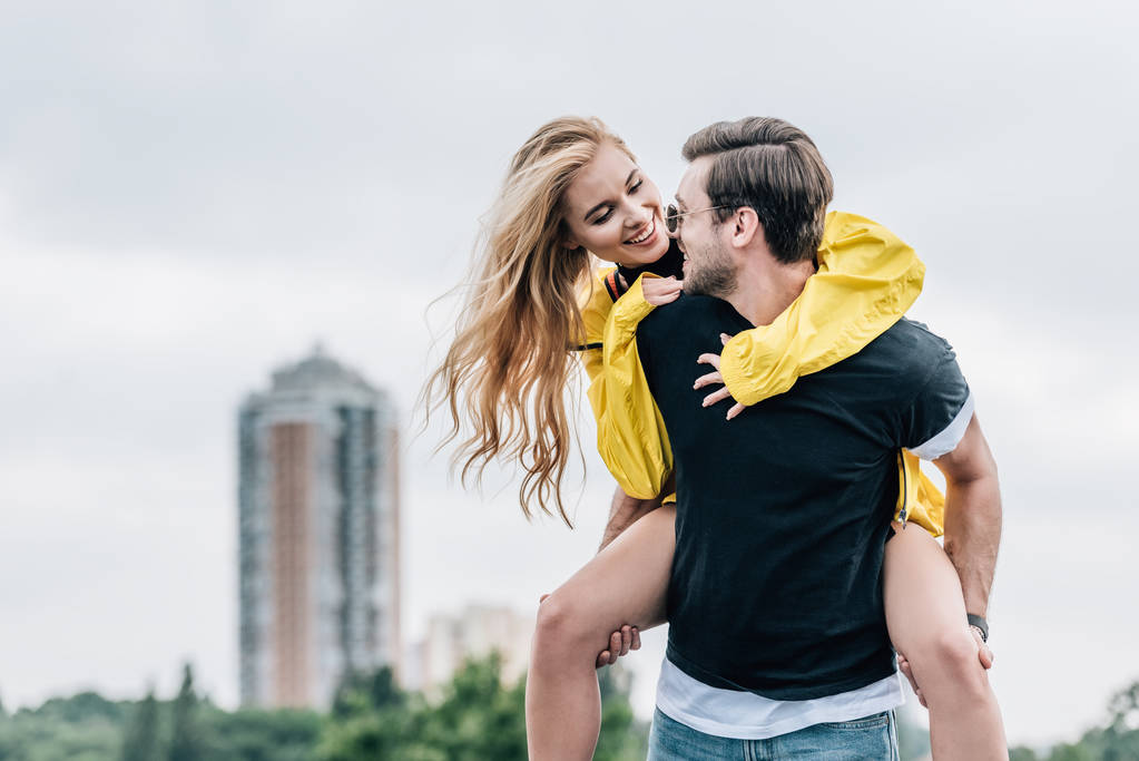 attractive woman and handsome man smiling and playing on roof  - Photo, Image